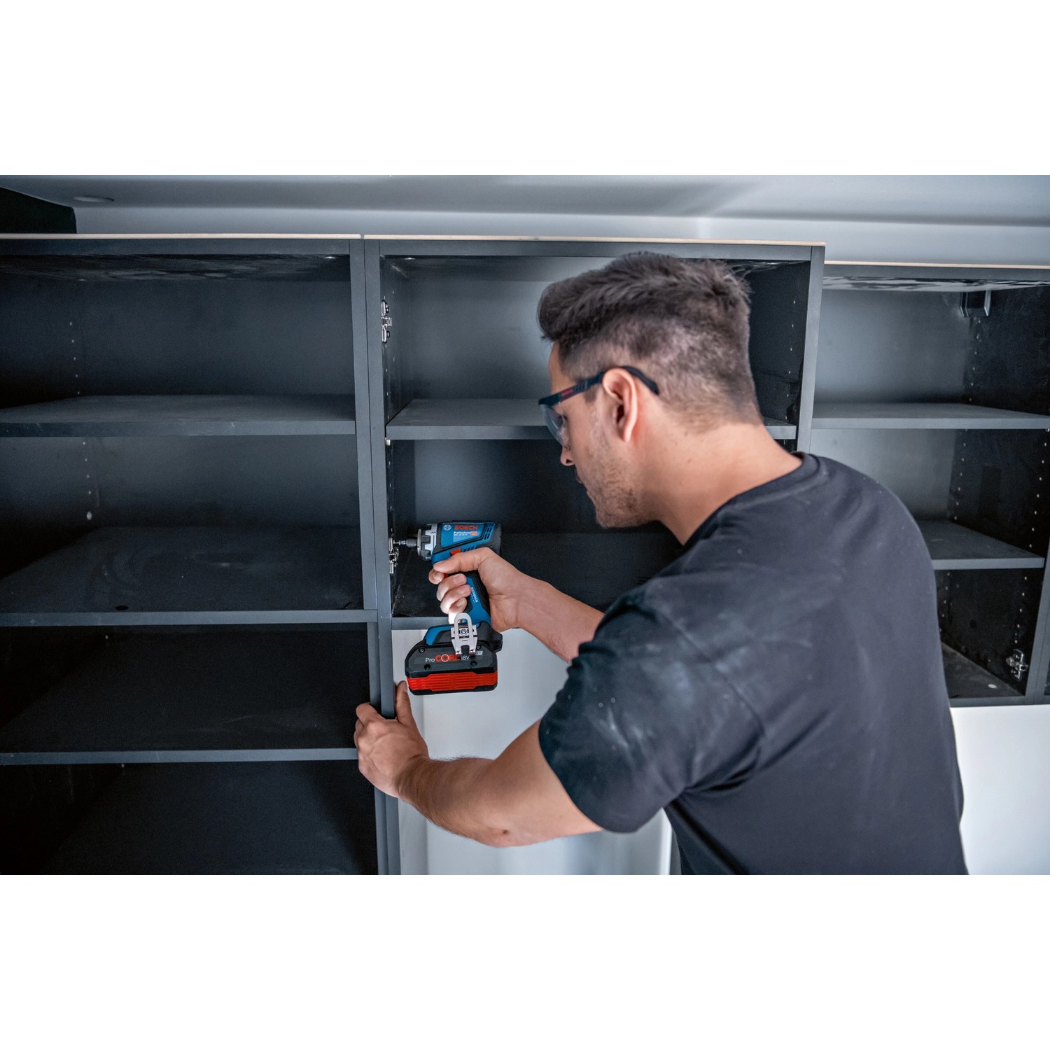 Handwerker schraubt mit dem Bosch Professional Akku-Bohrschrauber GSR 18V-90 FC an einem Regal.