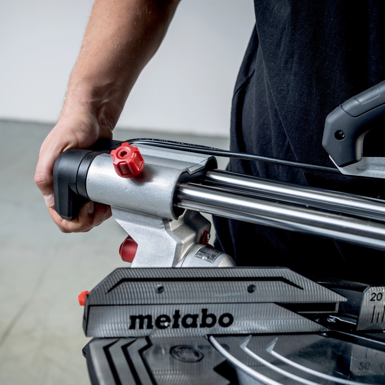 Detailaufnahme einer Metabo Kappsäge KGS 216 M mit Hand am Griff.