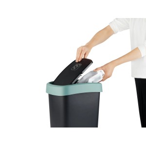 Rotho Swingeimer Twist, 10 l, Mistletoe Green: Person wirft Müll in schwarzen Eimer mit grünem Deckel.