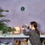 Frau benutzt Bosch Atino Linienlaser mit Maßband zum Ausrichten an Wand.