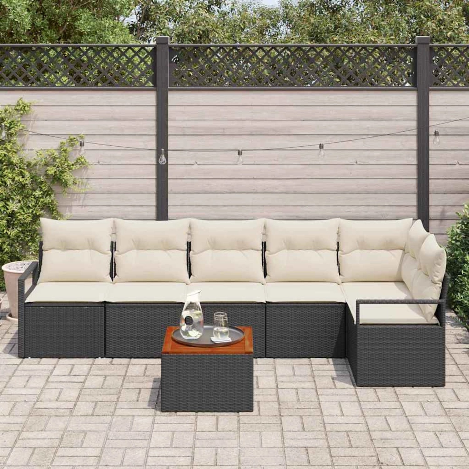 Schwarzes 7-teiliges Garten-Sofa-Set aus Poly Rattan mit Kissen und Tisch.