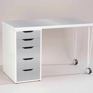 Schreibtisch mit Venilia Klebefolie Kreise Silber auf Tischplatte und Schubladen.