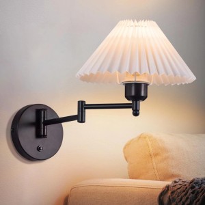 ZMH Wandleuchte, schwarz, mit weißem plissierten Stoffschirm und schwenkbarem Metallarm, leuchtend über einem Sofa.