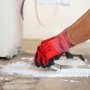 Anwendung von Soudal Fix All Floor & Wall Flächenkleber mit Spachtel, rote Handschuhe.