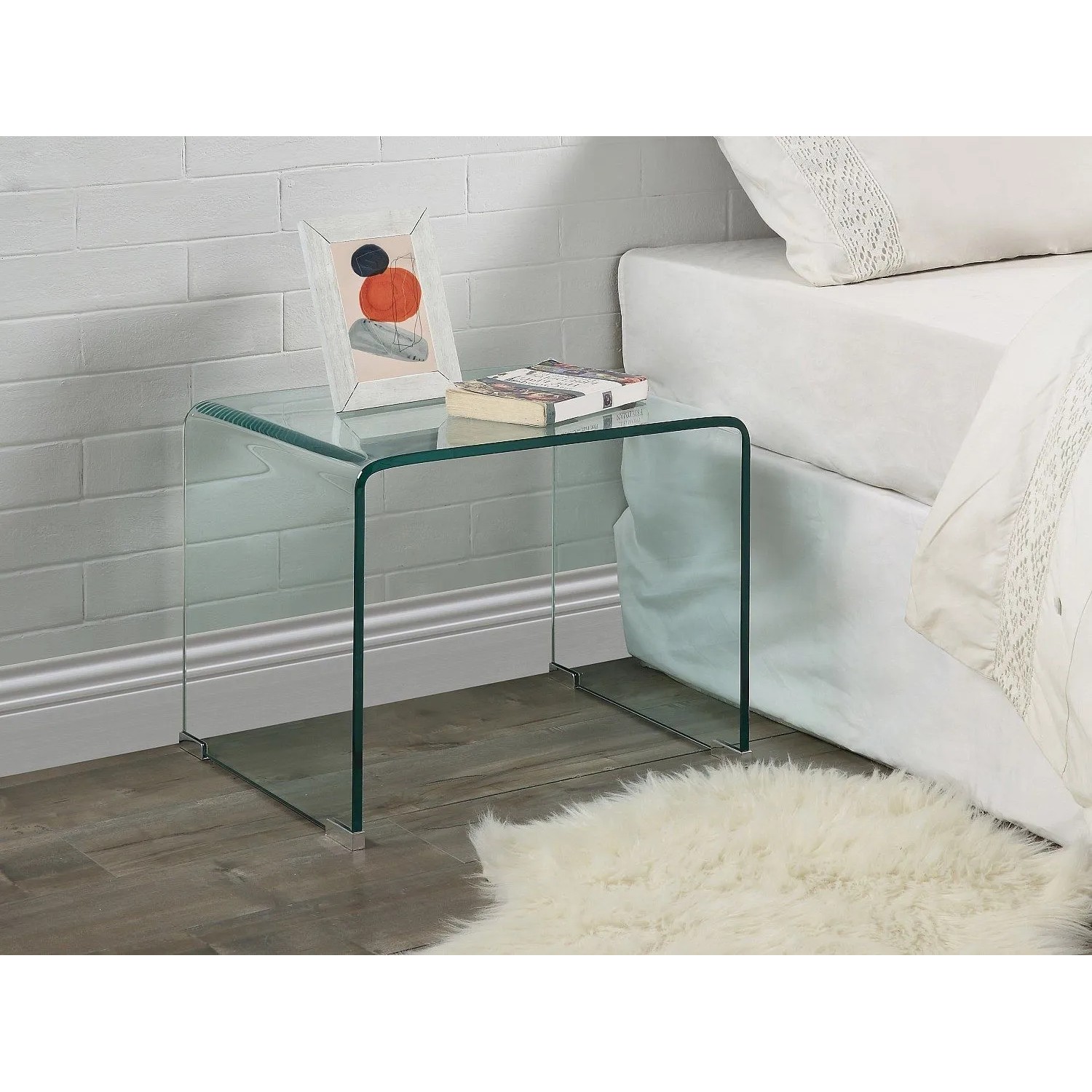 Transparenter Glas-Nachttisch Suzana 50 cm mit abgerundeten Kanten, neben einem Bett. Modernes Schlafzimmer-Möbel.