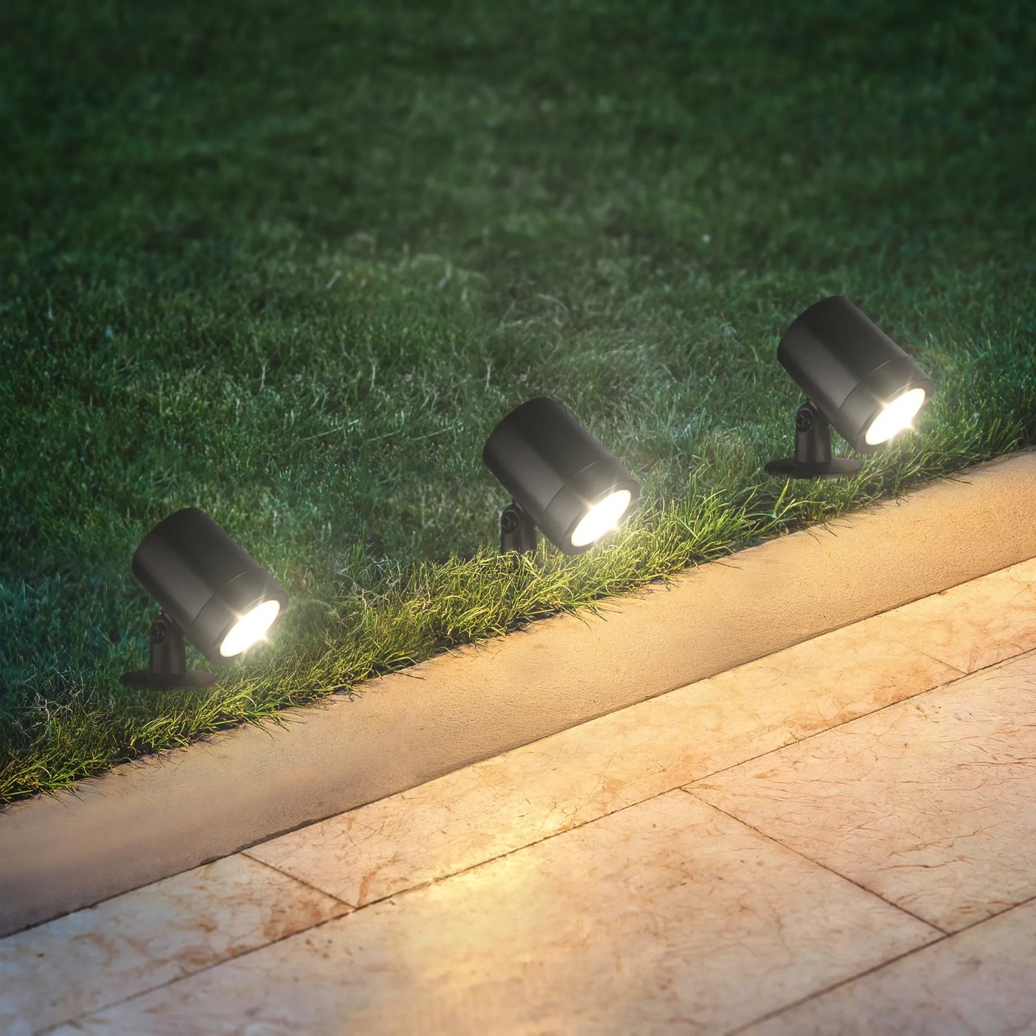 Brilo LED Gartenspieß-Set, drei schwarze schwenkbare Strahler im Garten.