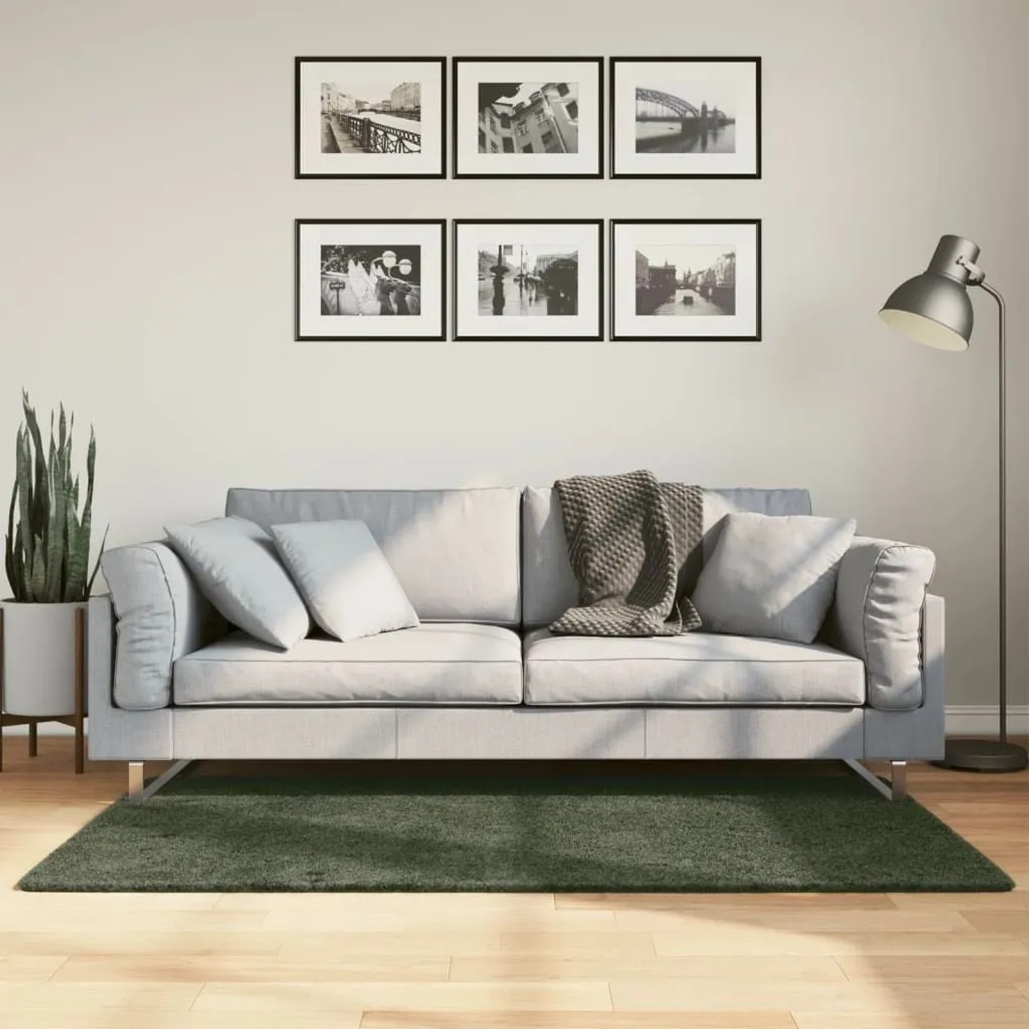 Waldgrüner Kurzflor Teppich HUARTE 80x150 cm im Wohnzimmer vor hellem Sofa. Weich, waschbar.