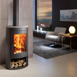 Schwarzer Panadero Oval 1 Kaminofen (8,7 kW) mit Holzscheiten im Wohnraum.