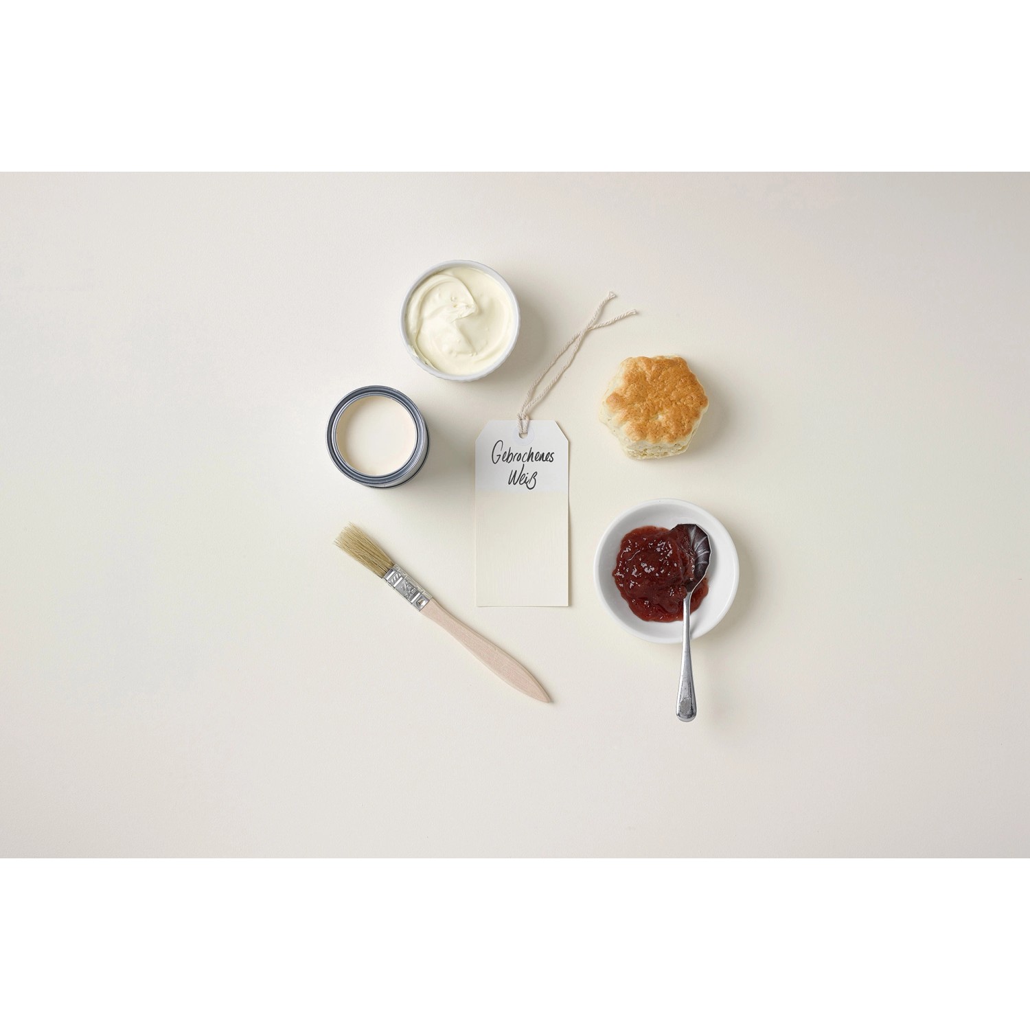 Rust-Oleum Kreidefarbe in Gebrochenes Weiß mit Pinsel, Marmelade und Brötchen auf hellem Grund.