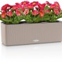 Lechuza Cube Color Triple Pflanzgefäß, sandbraun, mit pinkfarbenen Gerbera-Blumen.