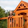 Kind im Backyard Discovery Spielturm Atlantic mit Rutsche und Schaukel, Holz, Grün/Gelb.