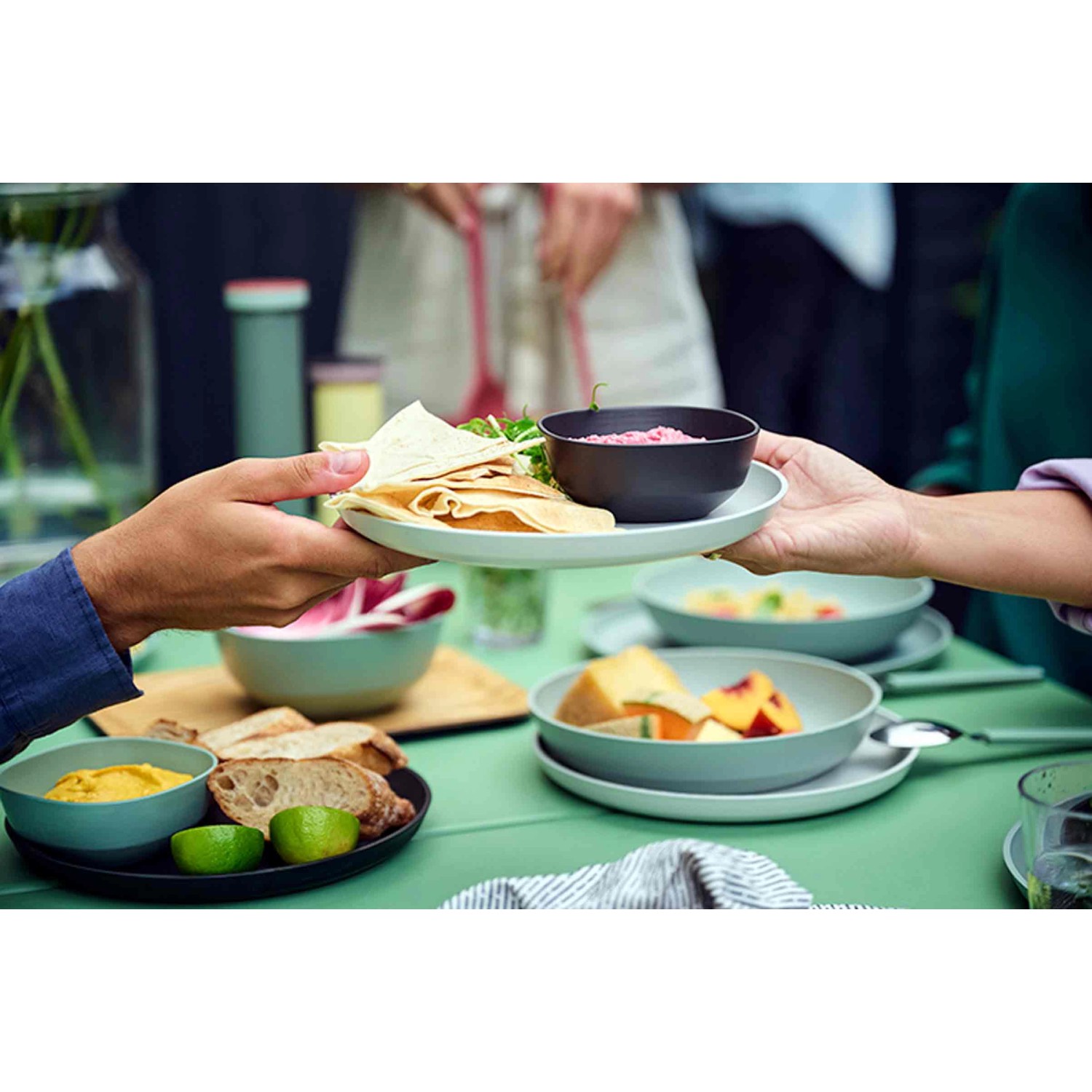 Mepal Silueta Essteller 4er Set Nordic White mit Speisen auf gedecktem Tisch.