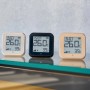 Shelly Temperatursensor Plus H&T G3 in Weiß, Schwarz und Beige auf Glasablage.