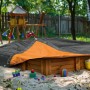 Orange-graue Gewebeplane 3x4 m als Abdeckung für Sandkasten im Garten.