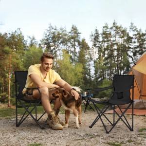 Schwarzer Sunula Campingstuhl mit Mann und Hund im Outdoor-Bereich.