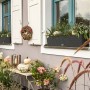 Lechuza Balconera Cottage 80 Blumenkasten in Granit mit Bepflanzung am Fenster.