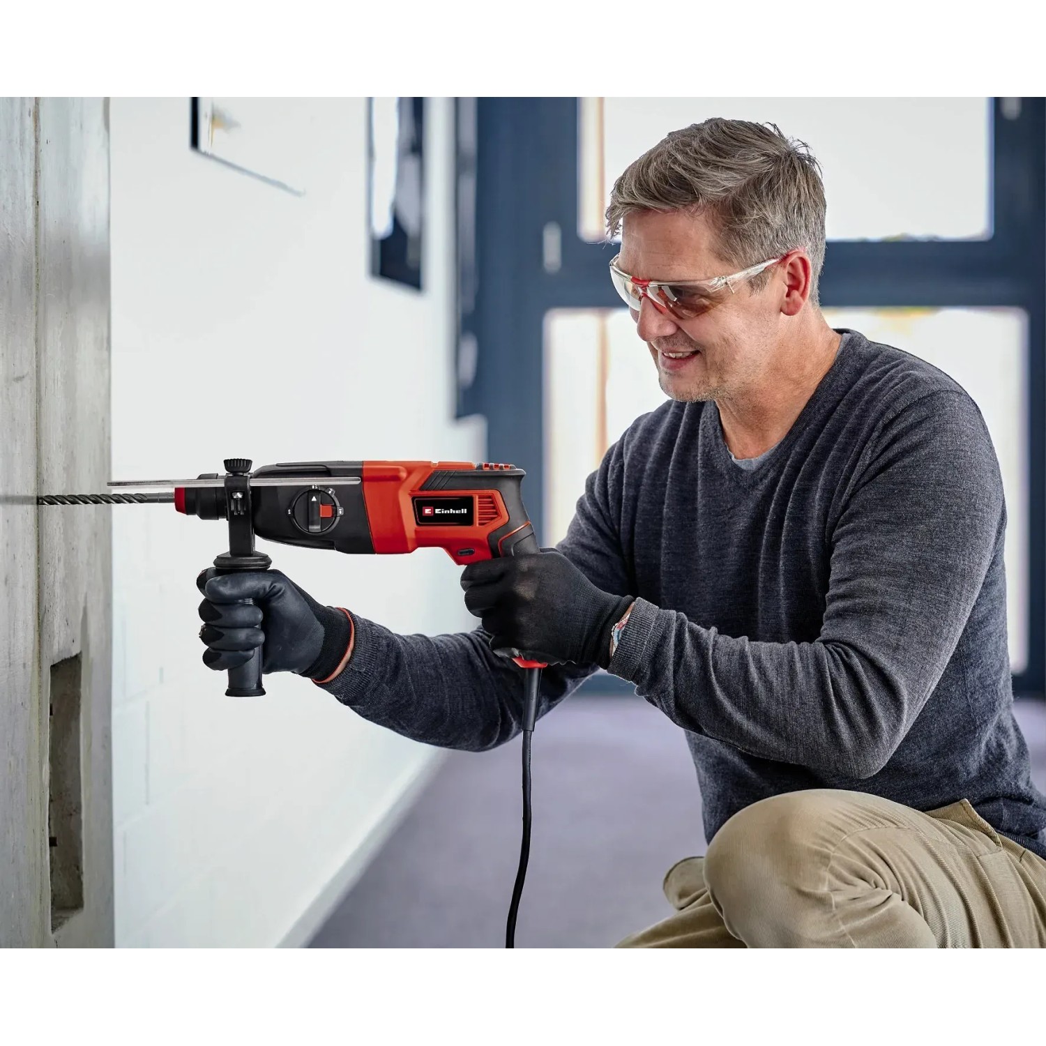 Mann bohrt mit dem Einhell Bohrhammer TC-RH 620 4F Kit ein Loch in eine Wand.