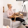 Frau nutzt kippbaren Bambus Laptoptisch auf Sofa. Ergonomischer Schreibtisch für Notebook mit Ablage und Schublade.