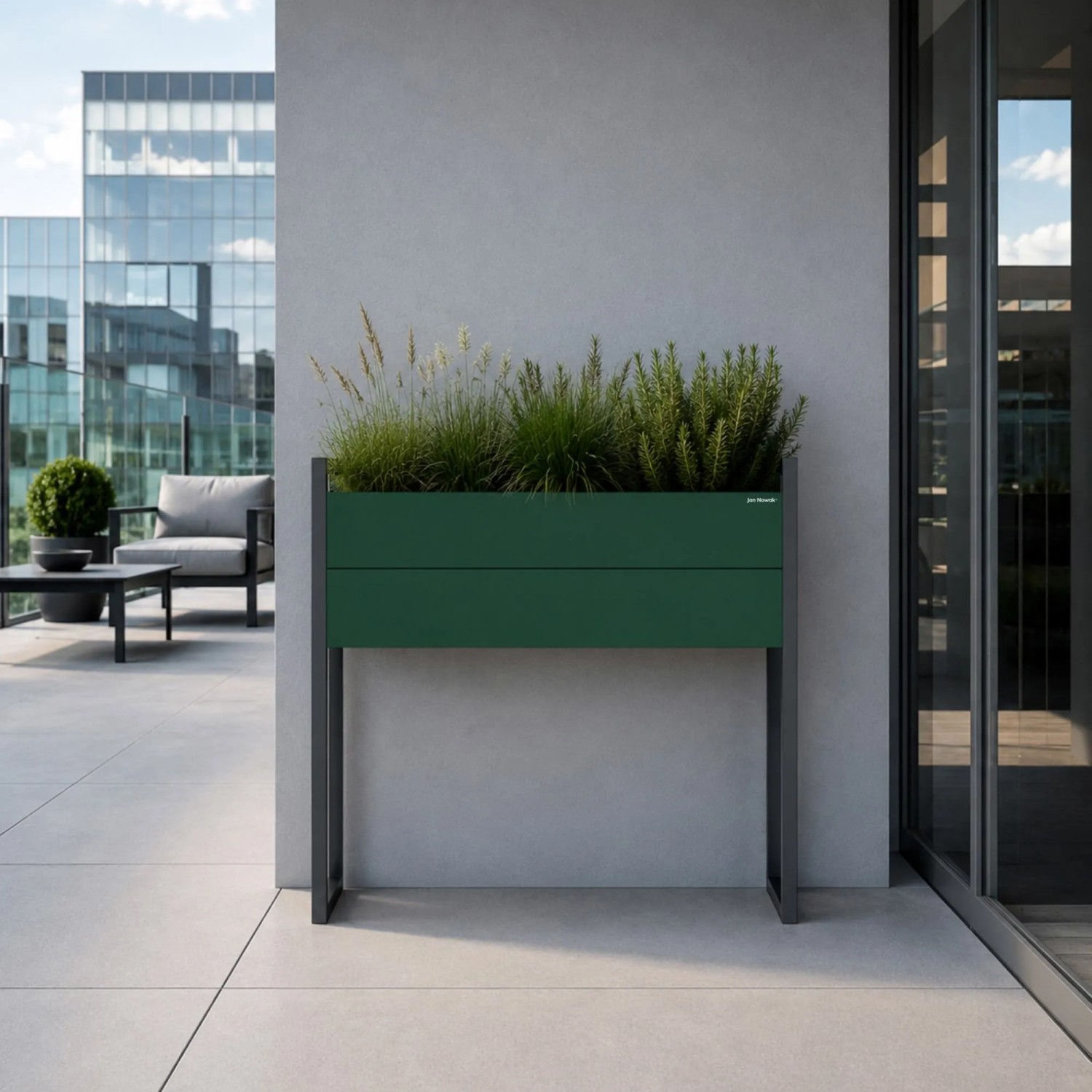 Hoher JAN NOWAK Blumenkübel MARGARET H aus flaschengrünem Metall mit anthrazitfarbenen Beinen, bepflanzt auf modernem Balkon. Robust.