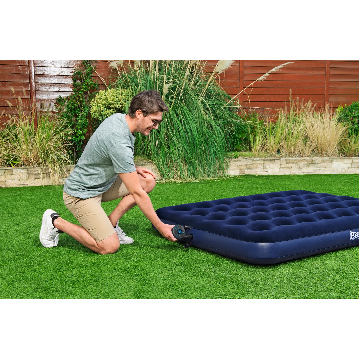 Mann pumpt blaue Luftmatratze mit Bestway PowerTouch Akku-Elektropumpe auf. Camping & Zubehör.