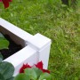 Detailansicht: Weißer KHW Pflanzkasten klein mit Spalier und Bepflanzung im Garten.