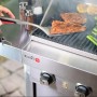Char-Broil Grillwender mit Comfort Grip im Einsatz auf einem Grill mit Fisch und Gemüse.