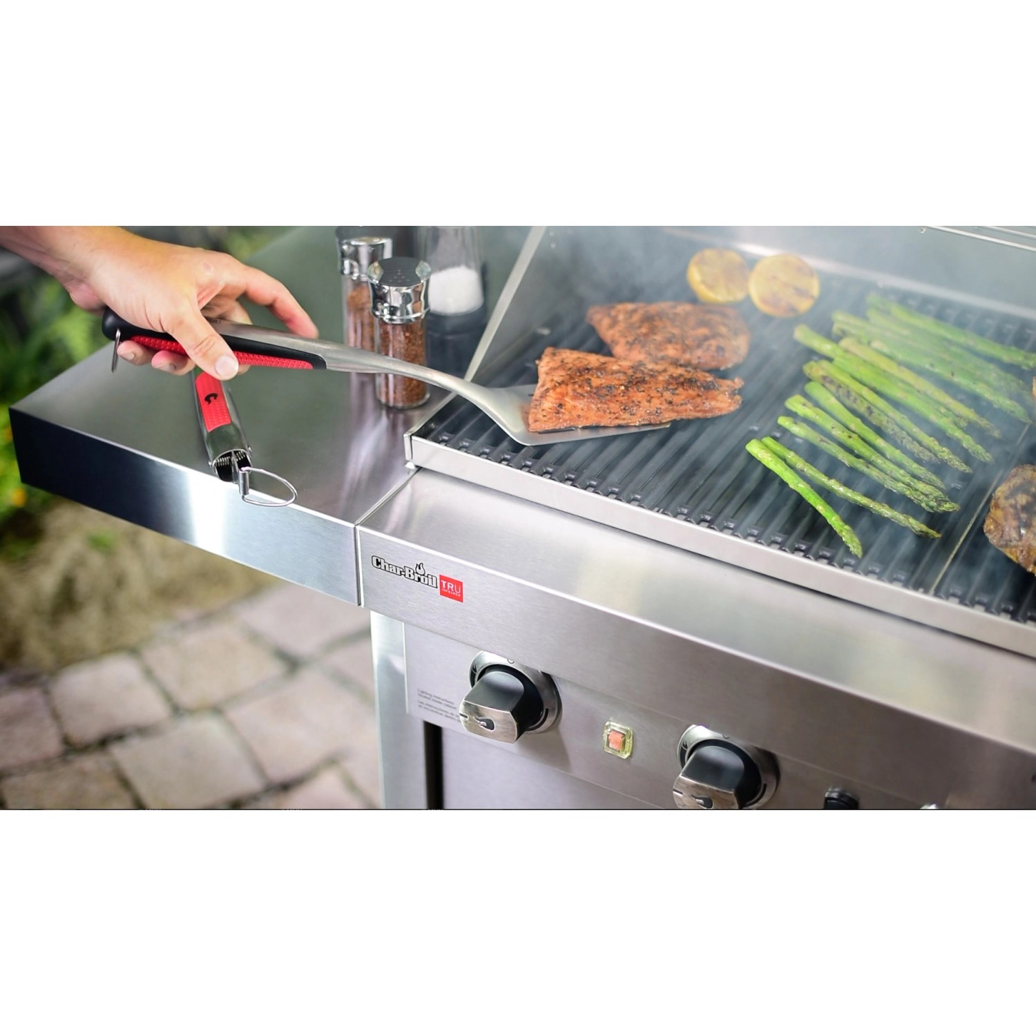 Char-Broil Grillwender mit Comfort Grip im Einsatz auf einem Grill mit Fisch und Gemüse.