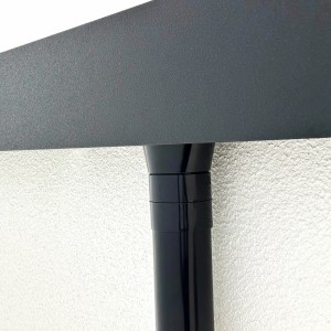 Detailaufnahme der Entwässerung am Amazing Spaces Gartenhaus Urban One. Schwarzes Fallrohr vor weißer Wand.