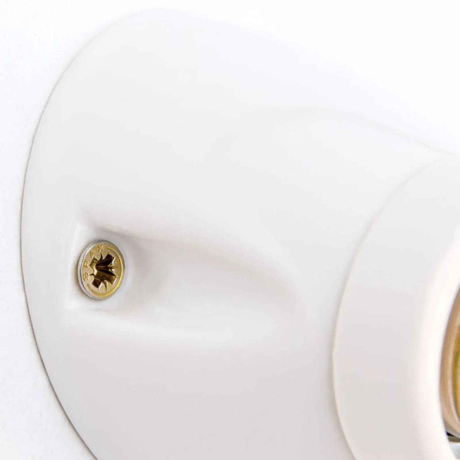 Detailaufnahme: Weiße Orion Keramik Wandleuchte mit E27 Fassung und Schraube.