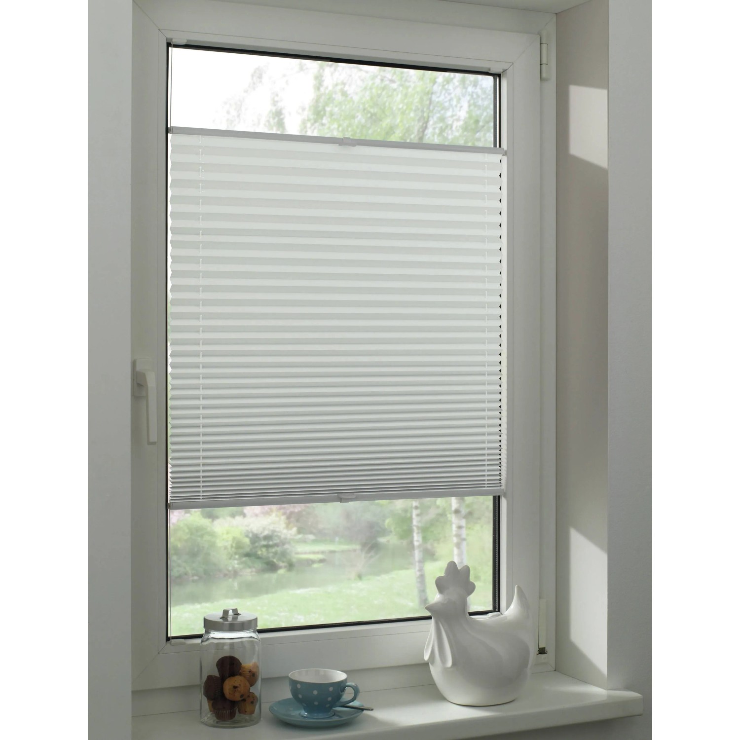 Weißes Gardinia Plissee Concept Thermo zur Abdunklung am Fenster montiert.
