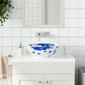 Rundes weiß-blaues Keramik Aufsatzwaschbecken mit floralem Muster in modernem Badezimmer.
