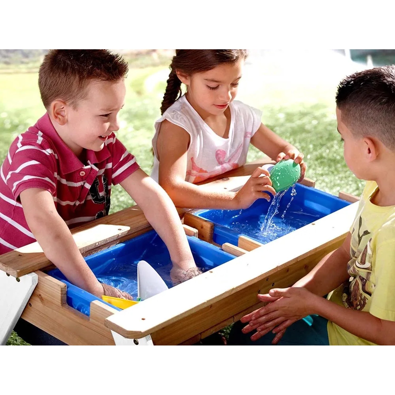 Kinder spielen am Axi Nick Sand- und Wasser-Picknicktisch mit Sonnenschirm im Garten.