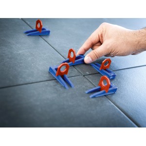 LUX Nivellierhilfe Startset mit Keilen und Clips (2 mm) im Einsatz zwischen Fliesen.