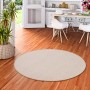 Runder, beiger Snapstyle Feinschlingen Velour Teppich Strong (133cm) auf Holzboden in Wohnraum.
