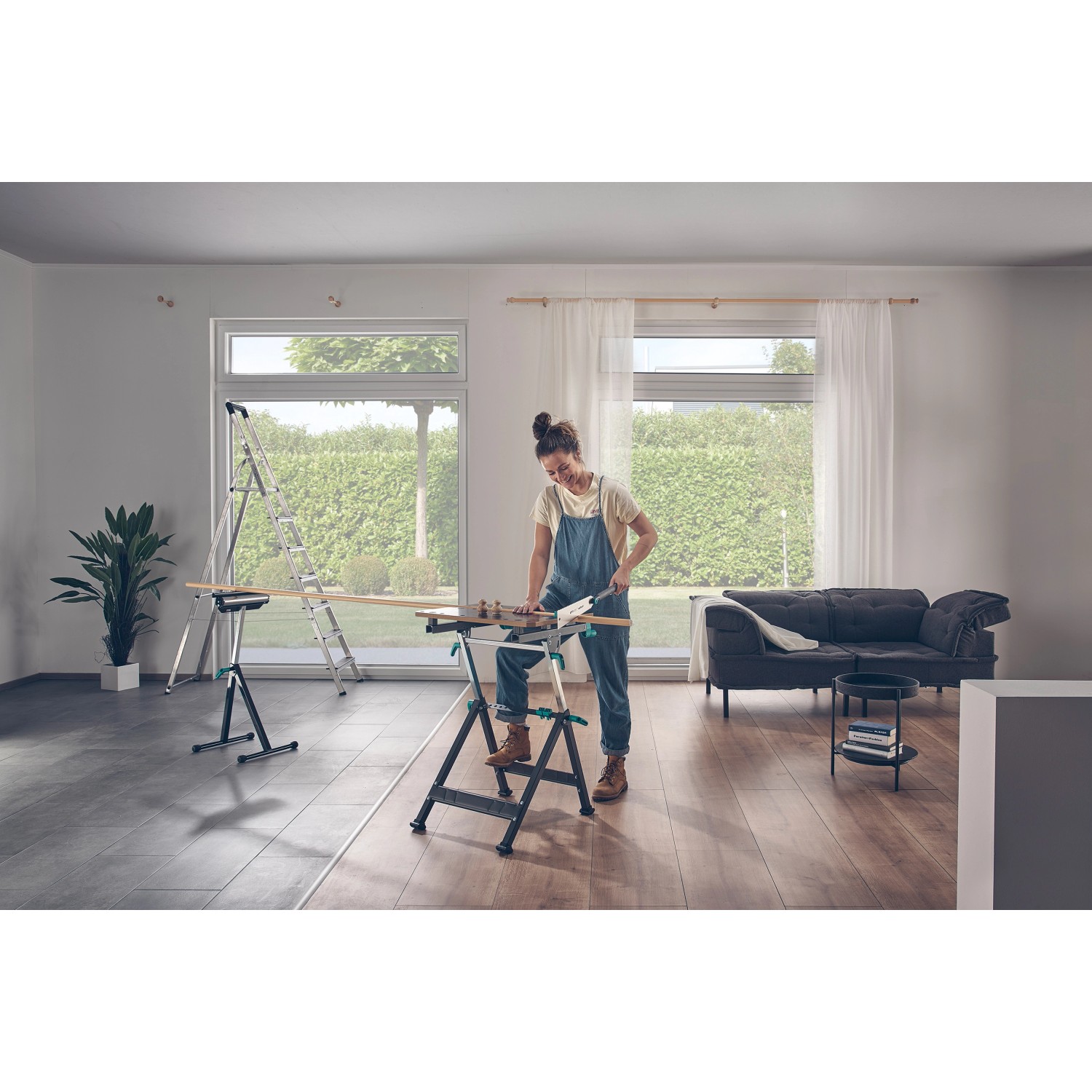 Frau sägt Holz auf wolfcraft Master 650 Ergo Werkbank. Höhenverstellbarer Arbeitstisch im Einsatz.