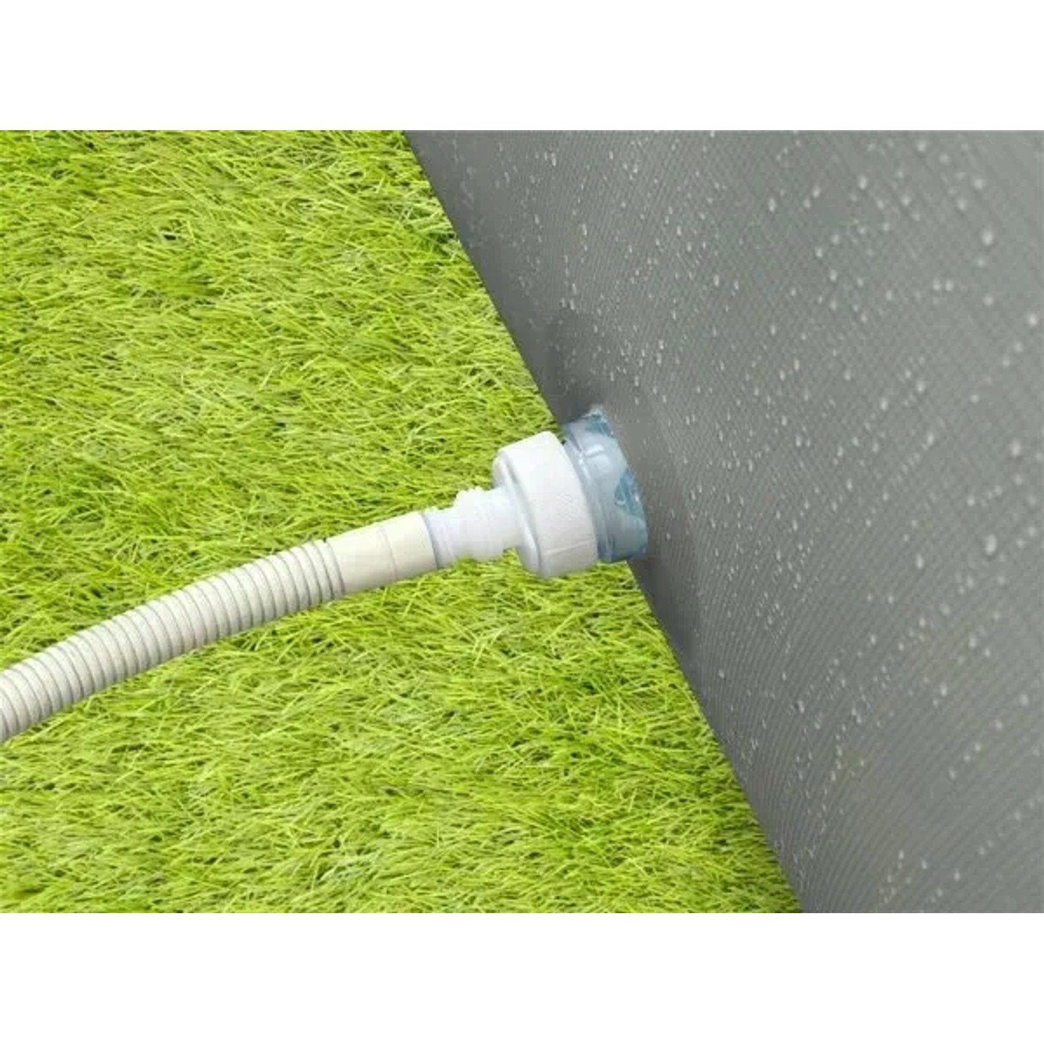 Detailaufnahme: Avenli Frame Pool Ablauf mit Schlauch auf Rasen. Rechteckiger Stahlrahmenpool, grau.