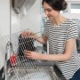 Frau reinigt Grillrost mit Vileda Glitzi Scheuerspirale (3er-Pack) in Spüle.