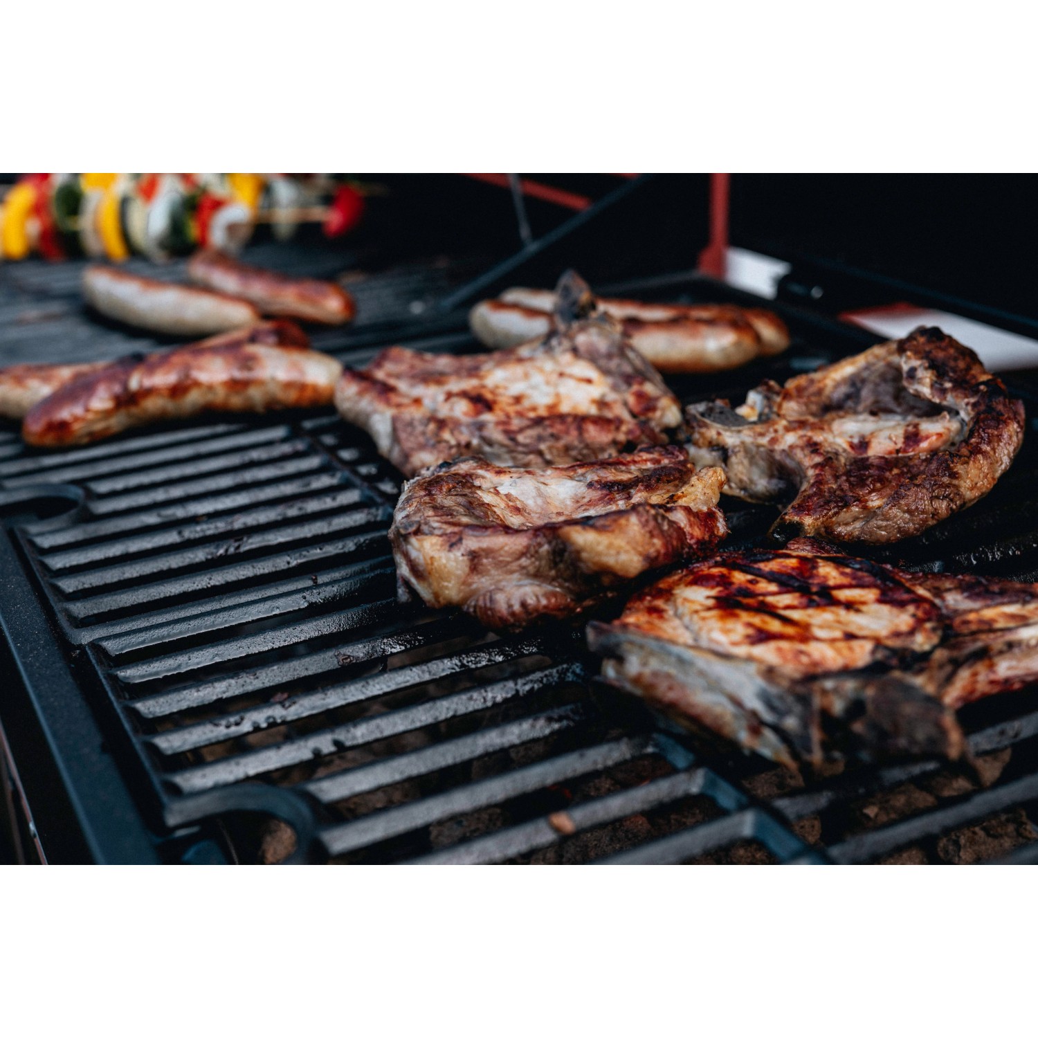 Grillgut auf Jamestown Kombigrill Drake: Steaks, Würstchen und Gemüsespieße auf dem Holzkohlegrill.