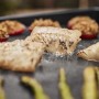 Weber Gasgrill Slate Plancha: Gegrillter Fisch, gefüllte Paprika und Spargel auf der Grillplatte.