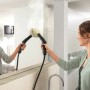Frau reinigt Spiegel mit Kärcher Dampfreiniger SC 3 EasyFix. Dampf sichtbar.