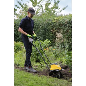 Frau benutzt gelbe Texas Elektro-Motorhacke El-Tex 750 im Garten.