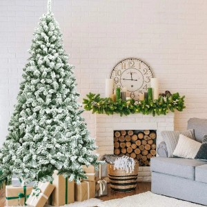 Großer, schneebedeckter künstlicher Weihnachtsbaum (225cm) mit PVC-Zweigen im Wohnzimmer, umgeben von Geschenken.