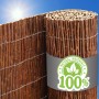 Braune Weidenmatte als Sichtschutzrolle, mit Drahtgeflecht und "100% Naturmaterial" Etikett, unter blauem Himmel.