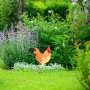 Gartenfigur Hahn aus Polyresin, braun, rot und gelb, wetterfest, im Garten zwischen Blumen.