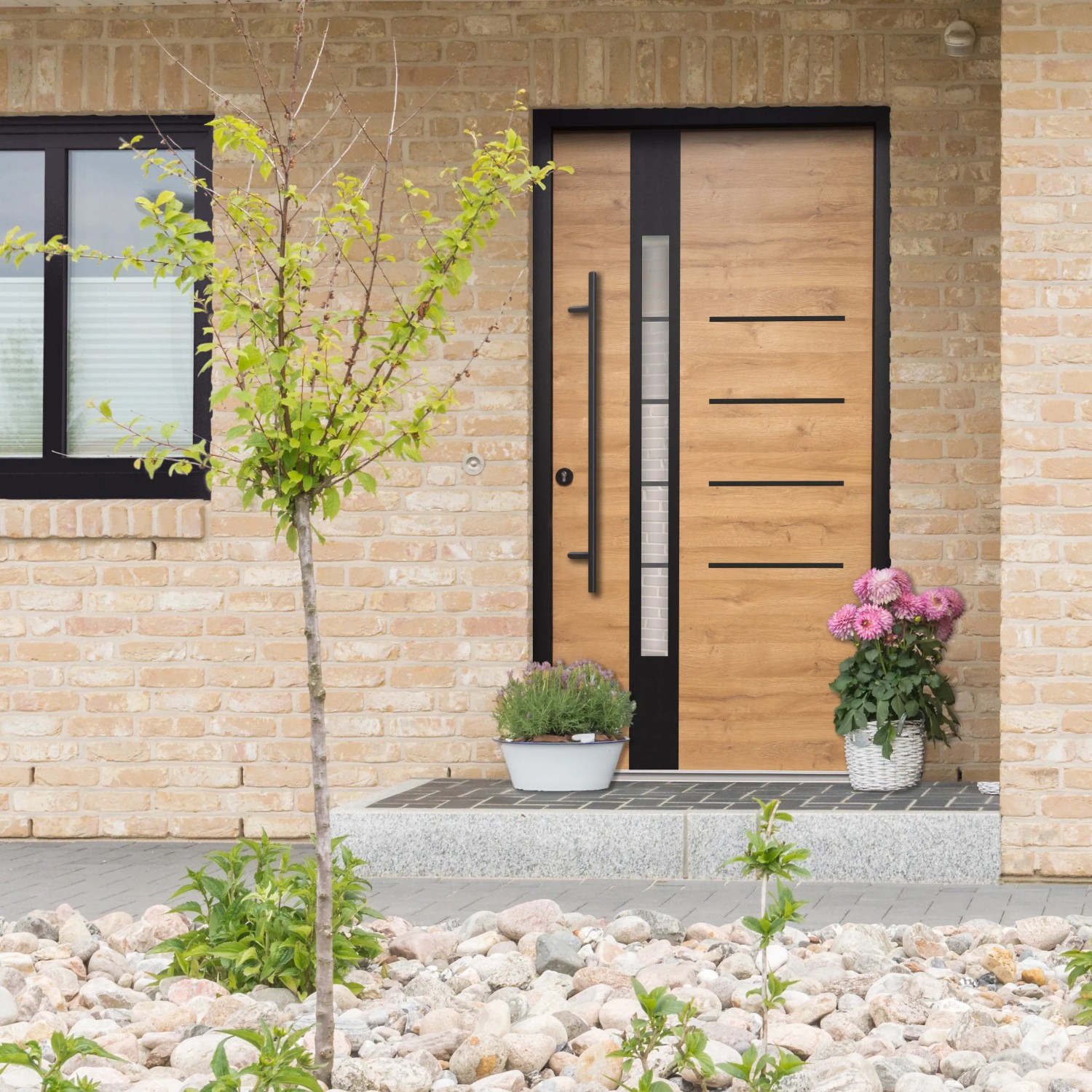 Moderne Splendoor Haustür Berlin Prime Woodeffect Eiche natur mit Edelstahl-Applikationen und schwarzem Rahmen.