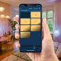Hand hält Smartphone mit Bosch Smart Home Dimmer App zur Lichtsteuerung im Wohnraum.