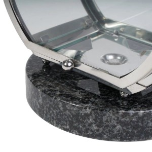 Nahaufnahme einer runden KOKA Grablampe aus dunklem Impala Granit und glänzendem Edelstahl mit geöffneter Tür für Grabkerzen.
