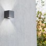 Moderne LED-Außenwandleuchte Gemini mini von Lutec, grauer Kubus mit Lichtstrahl nach oben und unten.