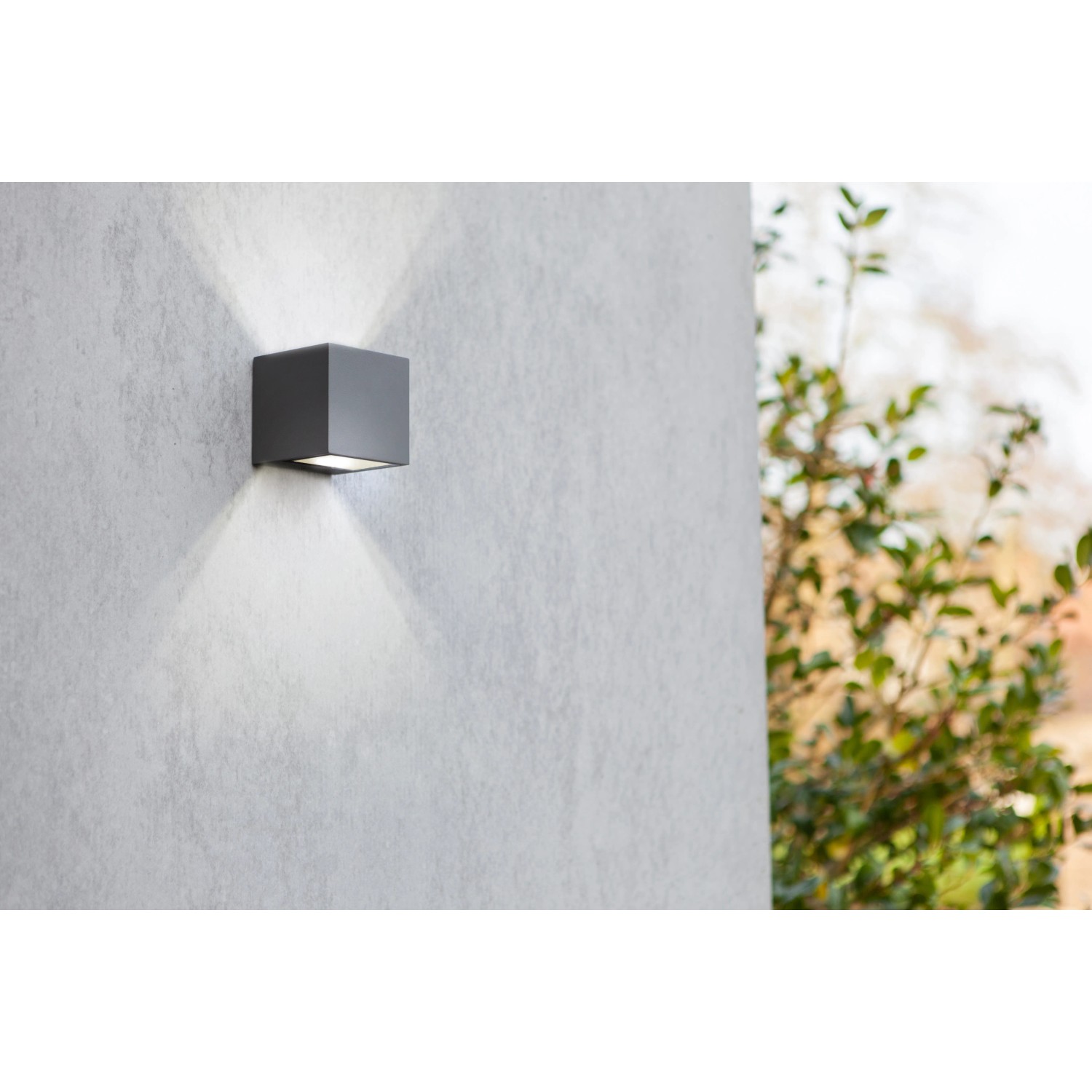 Moderne LED-Außenwandleuchte Gemini mini von Lutec, grauer Kubus mit Lichtstrahl nach oben und unten.