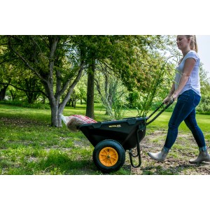 Schwarze Polar Schubkarre Cub Cart mit gelbem Rad und Frau bei der Gartenarbeit.